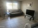 Cozy living room with tile floors, neutral paint, large windows, and glass end tables at 5110 N 42Nd Dr, Phoenix, AZ 85019