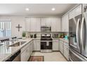 Bright kitchen features gray cabinets, stainless steel appliances, and granite countertops for modern living at 5724 N 108Th Ave, Phoenix, AZ 85037