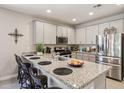 Open kitchen with bar seating, stainless steel appliances, granite counters, and ample cabinet space at 5724 N 108Th Ave, Phoenix, AZ 85037