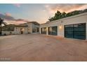 A large concrete driveway leads to a three-car garage featuring contemporary glass doors at 6432 E El Sendero Rd, Carefree, AZ 85377