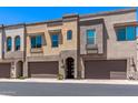 Street view of modern townhomes with attached garages, neutral stucco, and arched entryways at 7492 E Via De Luna Dr, Scottsdale, AZ 85255