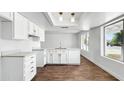 Bright kitchen featuring white cabinetry, an island with a sink, and a view to the front yard at 7730 W Mulberry Dr, Phoenix, AZ 85033