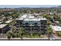 An aerial view shows the condo building among lush landscape, city buildings, and distant mountains at 914 E Osborn Rd # 404, Phoenix, AZ 85014