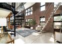 Charming living room with exposed brick, spiral staircase, and large windows bringing in natural light at 914 E Osborn Rd # 404, Phoenix, AZ 85014