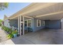 View of the carport featuring an outdoor living space with plants, and decorative home accents at 1003 E Mariposa St, Phoenix, AZ 85014