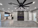 Modern living room featuring gray floors, sleek fireplace, recessed lighting, and an open floor plan connecting to the kitchen at 10637 N 16Th Ave, Phoenix, AZ 85029