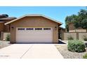 Beige stucco home exterior with a two-car garage and a well-maintained desert landscape at 12830 S Wakial S Loop, Phoenix, AZ 85044