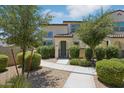 Charming two-story home with landscaped yard, walkway, and mature trees for curb appeal at 14870 W Encanto Blvd # 1091, Goodyear, AZ 85395