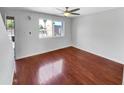 Bright, empty living room with hardwood floors, a ceiling fan, and a large window at 1750 E Mateo Cir # 103, Mesa, AZ 85204