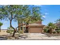 Attractive two-story home with a tan facade, tiled roof, desert landscaping, and an attached two car garage at 18132 W Cardinal Dr, Goodyear, AZ 85338