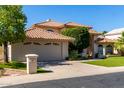 Beautiful home showcasing a tile roof, manicured lawn, and a spacious driveway leading to the garage at 1834 E Willow Tree Ct, Gilbert, AZ 85234