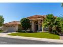 Inviting two-story home boasts a tile roof, well-kept lawn, and lush landscaping with mature trees at 1834 E Willow Tree Ct, Gilbert, AZ 85234