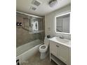 Well-lit bathroom featuring an updated vanity with an illuminated mirror, a bathtub with a shower, and neutral tiling at 1940 E Indianola E Ave, Phoenix, AZ 85016