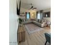 Inviting living room showcasing a large sectional sofa, modern ceiling fan, and stylish decor on floating shelves at 1940 E Indianola E Ave, Phoenix, AZ 85016