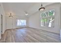 Bright, open-concept living room featuring modern light fixtures and beautiful wood floors at 21141 N 79Th Ave, Peoria, AZ 85382