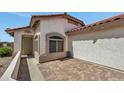 Close-up of home exterior with brick paved patio and stucco facade at 23075 W Arrow Dr, Buckeye, AZ 85326