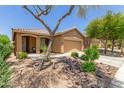 Charming single-story home featuring a well-manicured front yard, desert landscaping and a two-car garage at 2458 W Warren Dr, Anthem, AZ 85086