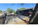 Traditional home with a covered parking area and mature trees, offering shade at 265 W 17Th Ave, Apache Junction, AZ 85120