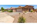 Beautiful house with desert landscaping, a two-car garage, and a well-maintained yard at 36538 W La Paz St, Maricopa, AZ 85138