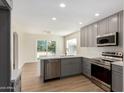 Modern kitchen featuring gray cabinets, stainless steel appliances, and wood-style floors at 4031 W Lone Cactus Dr, Glendale, AZ 85308