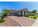 Beautiful home featuring a brick driveway, desert landscaping, and charming architectural details at 4442 E Fairbrook St, Mesa, AZ 85205