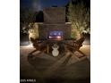 Cozy outdoor fireplace with brick surround and comfortable Adirondack chairs at night at 4442 E Fairbrook St, Mesa, AZ 85205