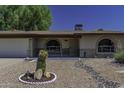 Front exterior of the home, featuring a desert landscape, covered entry, and brick accents at 5148 E Edgewood Cir, Mesa, AZ 85206