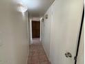 Hallway with tile flooring and two white doors leading to rooms and a visible door at the end at 5634 W Puget Ave, Glendale, AZ 85302
