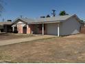 Single story home featuring a pink exterior, attached garage, and a driveway at 6231 N 25Th Ave, Phoenix, AZ 85015
