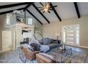 Bright living room featuring high ceilings with beams, modern decor, and glass staircase at 753 W 6Th Dr, Mesa, AZ 85210