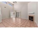 Spacious living room with high ceilings, tile flooring, a fireplace, and lots of natural light at 7621 S Bonarden Ln, Tempe, AZ 85284
