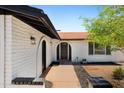 Inviting home exterior featuring an arched entryway, brick accents, and fresh landscaping at 811 E Brown St, Phoenix, AZ 85020