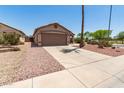 A single-story home with a large driveway, desert landscaping, and attached two-car garage at 8609 W Eva St, Peoria, AZ 85345