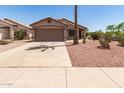 Single-story home showcasing desert landscaping, a two-car garage, and concrete driveway at 8609 W Eva St, Peoria, AZ 85345