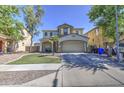 Front view of two-story home with desert landscaping, a spacious driveway, and a two-car garage in a residential area at 8769 W Washington St, Tolleson, AZ 85353