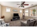 Cozy living room featuring a ceiling fan, plush carpet, and lots of natural light from multiple windows at 10062 E Isleta Ave, Mesa, AZ 85209