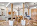 Bright dining area featuring an elegant chandelier, rustic wooden columns, and travertine tile floors at 1032 E Dolores Rd, Phoenix, AZ 85086