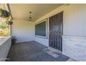 Cozy front porch features brick accents, decorative tile, and a secure metal security door at 11133 W Cameo Dr, Sun City, AZ 85351