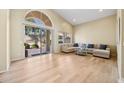 Spacious living area with blonde wood floors, large windows, and glass door to the outside at 11816 E Terra Dr, Scottsdale, AZ 85259