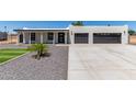 Attractive home featuring a two-car garage, xeriscaping, manicured grass and concrete driveway at 13012 N 36Th Dr, Phoenix, AZ 85029