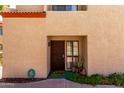 Exterior view of the townhouse showcases its neutral stucco facade and tiled roofline at 1401 E Puget Ave # 10, Phoenix, AZ 85020