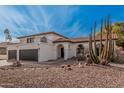 Beautiful property showcasing desert landscaping, a private balcony, and a spacious three-car garage at 15806 N 45Th Pl, Phoenix, AZ 85032
