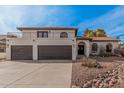 Inviting two-story home featuring a balcony, beautiful desert landscaping, and a spacious three-car garage at 15806 N 45Th Pl, Phoenix, AZ 85032