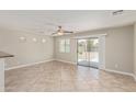 Bright living room with tile floors and sliding glass doors to the backyard at 17471 W Watson Ln, Surprise, AZ 85388