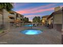 Resort-style pool and spa area with lounge chairs and lush landscaping at sunset at 2134 E Broadway Rd # 2031, Tempe, AZ 85282