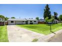 Inviting home with a well-kept lawn and a long driveway on a sunny day at 215 W Ruth Ave, Phoenix, AZ 85021
