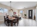 Open-concept living room with wood tile flooring, dining area, and plenty of natural light at 2221 W Calle De Las Estrella Way, Phoenix, AZ 85085