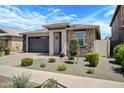 Inviting single-story home featuring a stone facade, desert landscaping, and a two-car garage at 22476 E Indiana Ave, Queen Creek, AZ 85142