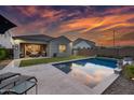 Relaxing backyard features a refreshing pool, patio seating, and lush green lawn perfect for outdoor entertainment at 2324 E Saguaro Park Ln, Phoenix, AZ 85024