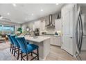 Modern kitchen boasts white cabinetry, stainless steel appliances, an island with bar seating, and stylish backsplash at 2324 E Saguaro Park Ln, Phoenix, AZ 85024